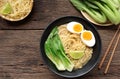 Delicious miso ramen noodles with egg in a bowl on a wood background.Top view Royalty Free Stock Photo