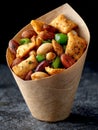 Delicious mixed nuts in a paper cone on a dark background. Royalty Free Stock Photo