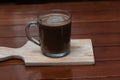 Delicious mocha flavored coffee in a cup on a wooden cutting board.