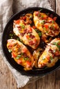 Delicious Monterey chicken breast baked with cheese, bacon, tomatoes and barbecue sauce close-up. Vertical top view Royalty Free Stock Photo