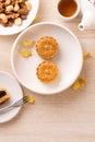 Delicious moon cake for Mid-Autumn festival with beautiful pattern, decorated with yellow flowers and tea. Concept of festive