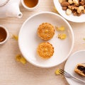 Delicious moon cake for Mid-Autumn festival with beautiful pattern, decorated with yellow flowers and tea. Concept of festive