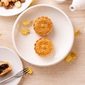 Delicious moon cake for Mid-Autumn festival with beautiful pattern, decorated with yellow flowers and tea. Concept of festive