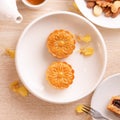 Delicious moon cake for Mid-Autumn festival with beautiful pattern, decorated with yellow flowers and tea. Concept of festive