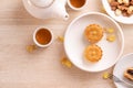 Delicious moon cake for Mid-Autumn festival with beautiful pattern, decorated with yellow flowers and tea. Concept of festive