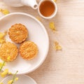 Delicious moon cake for Mid-Autumn festival with beautiful pattern, decorated with yellow flowers and tea. Concept of festive