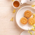 Delicious moon cake for Mid-Autumn festival with beautiful pattern, decorated with yellow flowers and tea. Concept of festive