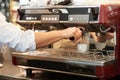 Delicious morning coffee. Male making a fresh cup of coffee in a cafe using a professional coffee machine.