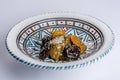 Delicious moroccan sweet dessert with prunes and dried apricots on a white ceramic plate with multicolor decoration