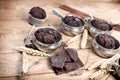 Chocolate muffin in old rustic silver cup and dark chocolate on wooden table