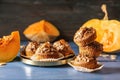 Delicious muffins with sunflower seeds and cut pumpkin on color table Royalty Free Stock Photo