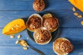 Delicious muffins with sunflower seeds and cut pumpkin on color wooden table Royalty Free Stock Photo