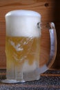 Delicious mug of super cold and refreshing draft beer on the table in the blurred background Royalty Free Stock Photo