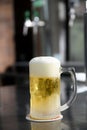 Delicious mug of super cold and refreshing draft beer on the table in the blurred background Royalty Free Stock Photo