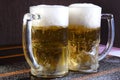 Delicious mug of super cold and refreshing draft beer on the table in the blurred background Royalty Free Stock Photo