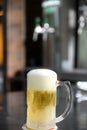 Delicious mug of super cold and refreshing draft beer on the table in the blurred background Royalty Free Stock Photo