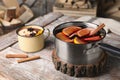 Delicious mulled wine and cinnamon on wooden table Royalty Free Stock Photo