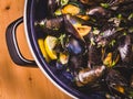 Delicious mussel in a blue pan on a wooden background close-up, top view