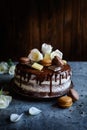 Naked cake filled with mascarpone cream, topped with chocolate and decorated with flowers, macarons and chocolate pieces Royalty Free Stock Photo