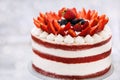 Delicious naked red velvet cake decorated with cream and fresh berries Royalty Free Stock Photo