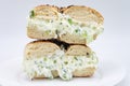Cut in Half and Stacked New York City Style Toasted Everything Bagel filled with Scallion Cream Cheese on a White Plate Royalty Free Stock Photo