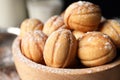 Delicious nut shaped cookies with powdered sugar in wooden bowl, closeup Royalty Free Stock Photo