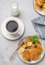 Delicious oat banana pancakes with fresh fruit slices, berries and honey on a light background with a cup of black coffee and milk Royalty Free Stock Photo