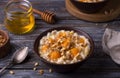 Delicious oatmeal porridge with baked pumpkin, honey and nuts in ceramic bowl on wooden table