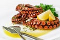 Delicious octopus salad with dressing, lemon and parsley on white background. Healthy eating.