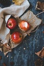 Delicious old fashioned caramel apples with twig sticks and autumn decoration. Autumn background top view Royalty Free Stock Photo