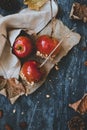 Delicious old fashioned caramel apples with twig sticks and autumn decoration. Autumn background top view Royalty Free Stock Photo