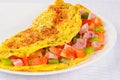 Delicious omelet with tomato, pepper, ham, basil