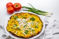 Delicious omelette served served with fresh green onion and tomatoes on white decor