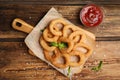 Delicious onion rings and ketchup on table, flat lay Royalty Free Stock Photo