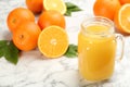 Delicious orange juice and fresh fruits on white marble table, closeup. Space for text Royalty Free Stock Photo