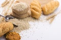 Delicious organic bread with wheat ears and wheat grains There is space to copy text. On a white table top in a rustic kitchen - Royalty Free Stock Photo