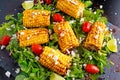 Delicious oven cooked Corn with feta cheese, paprika, lime, vegetables.