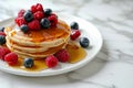 Delicious pancakes with berries, honey or maple syrup. Homemade pancakes and sweet syrup on white plate isolated. Royalty Free Stock Photo