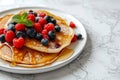 Delicious pancakes with berries, honey or maple syrup. Homemade pancakes and sweet syrup on white plate isolated. Royalty Free Stock Photo