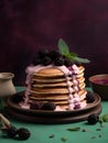 Delicious pancakes cake with fresh blackberries, cream and mint leaf on a nice dusty pink and green color background