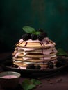 Delicious pancakes cake with fresh blackberries, cream and mint leaf on a nice dusty pink and green color background