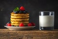 Delicious pancakes with fresh berries and glass of milk on rustic wooden table. Food concept Royalty Free Stock Photo