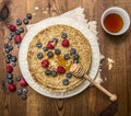 Delicious pancakes with fresh berries with honey, almonds cup of tea with honey spoon on white plate with napkin on wooden rustic