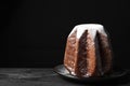 Delicious Pandoro cake with powdered sugar on dark table, space for text. Traditional Italian pastry