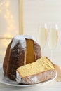 Delicious Pandoro cake decorated with powdered sugar and glasses of sparkling wine on white wooden table. Traditional Italian Royalty Free Stock Photo