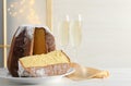 Delicious Pandoro cake decorated with powdered sugar and glasses of sparkling wine on white wooden table, space for text. Royalty Free Stock Photo