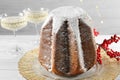 Delicious Pandoro cake decorated with powdered sugar and sparkling wine on white wooden table, closeup. Traditional Italian pastry Royalty Free Stock Photo