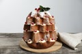Delicious Pandoro Christmas tree cake with powdered sugar and berries on wooden table