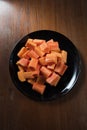 Delicious papaya on the black dish and wood background