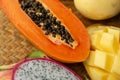 Delicious Papaya Top View on Wicker Mat and Exotic Fruits Background